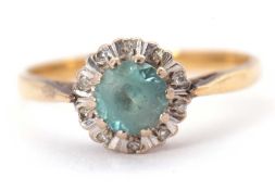 An 18ct blue zircon and diamond ring, the central round blue zircon surrounded by illusion set