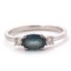 A 9ct sapphire and diamond ring, the oval blue-green sapphire set to either side with a round - Image 1 of 8