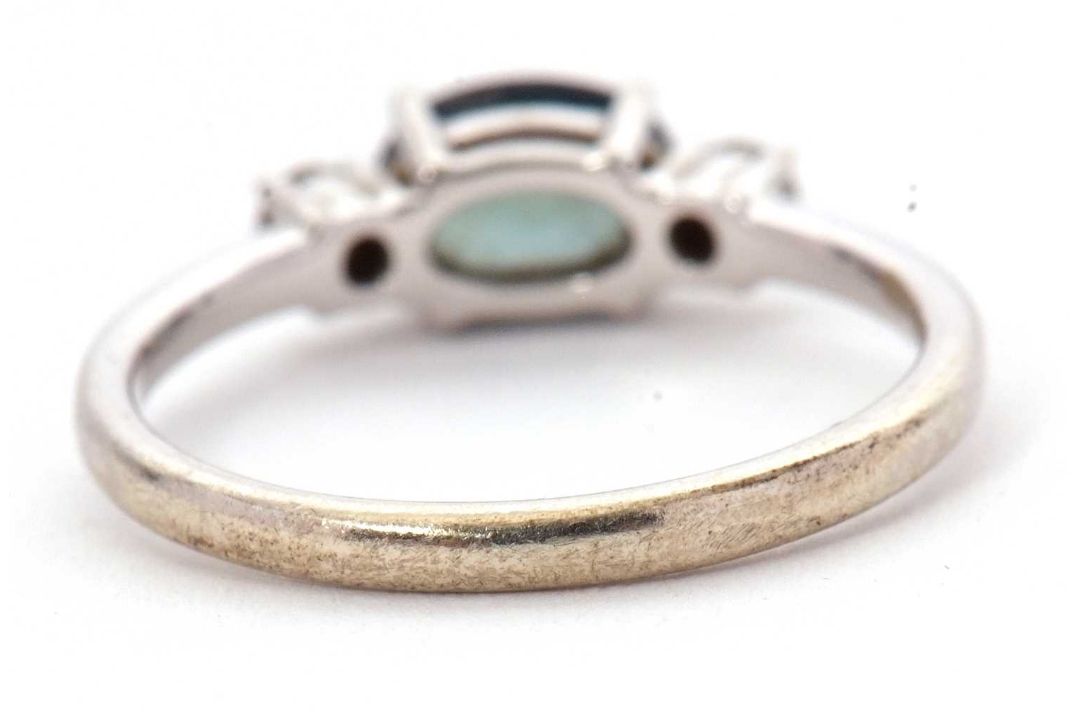 A 9ct sapphire and diamond ring, the oval blue-green sapphire set to either side with a round - Image 4 of 8