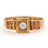 A late Victorian 18ct ruby and pearl ring, the central split pearl with four small rubies to