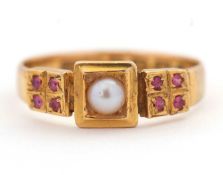 A late Victorian 18ct ruby and pearl ring, the central split pearl with four small rubies to