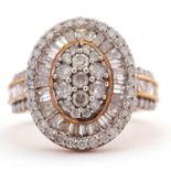A 9ct diamond ring, with a central oval pave diamond panel, surrounded by tapered diamond baguettes,