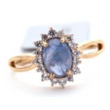 A 9ct sapphire and white zircon ring, the central oval sapphire cabochone, surrounded by small round