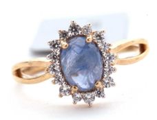 A 9ct sapphire and white zircon ring, the central oval sapphire cabochone, surrounded by small round