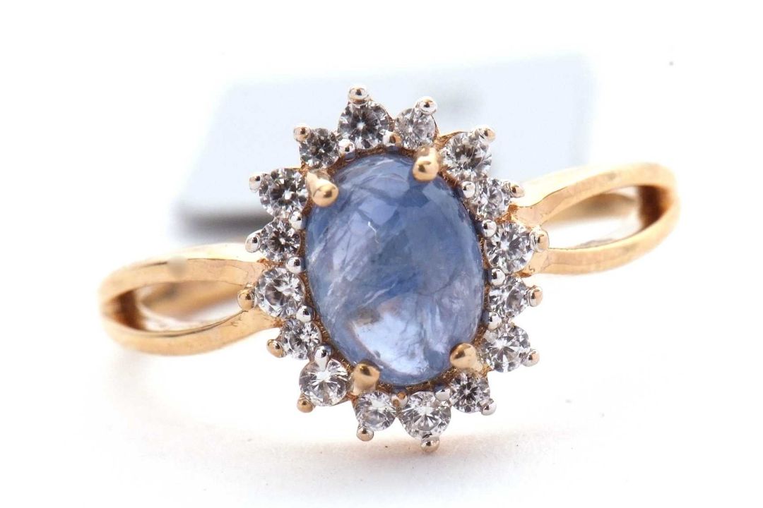 A 9ct sapphire and white zircon ring, the central oval sapphire cabochone, surrounded by small round - Image 1 of 6