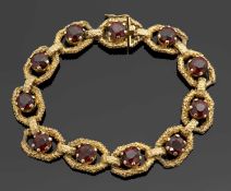 A 9ct garnet bracelet, the textured links set to centre with a round garnet, with integrated clasp