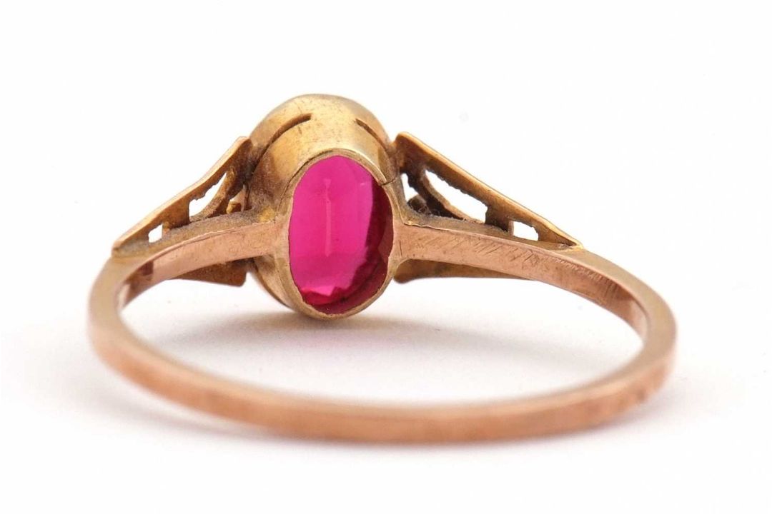 A synthetic ruby ring, the oval synthetic ruby with tapered shoulders and plain band stamped 9ct, - Image 3 of 8