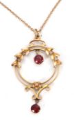 An early 20th century necklace, the open frame pendant set with a red hardstone to centre and