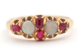 An opal and ruby ring, wtih two round opal cabochons and small round faceted rubies, with tapered