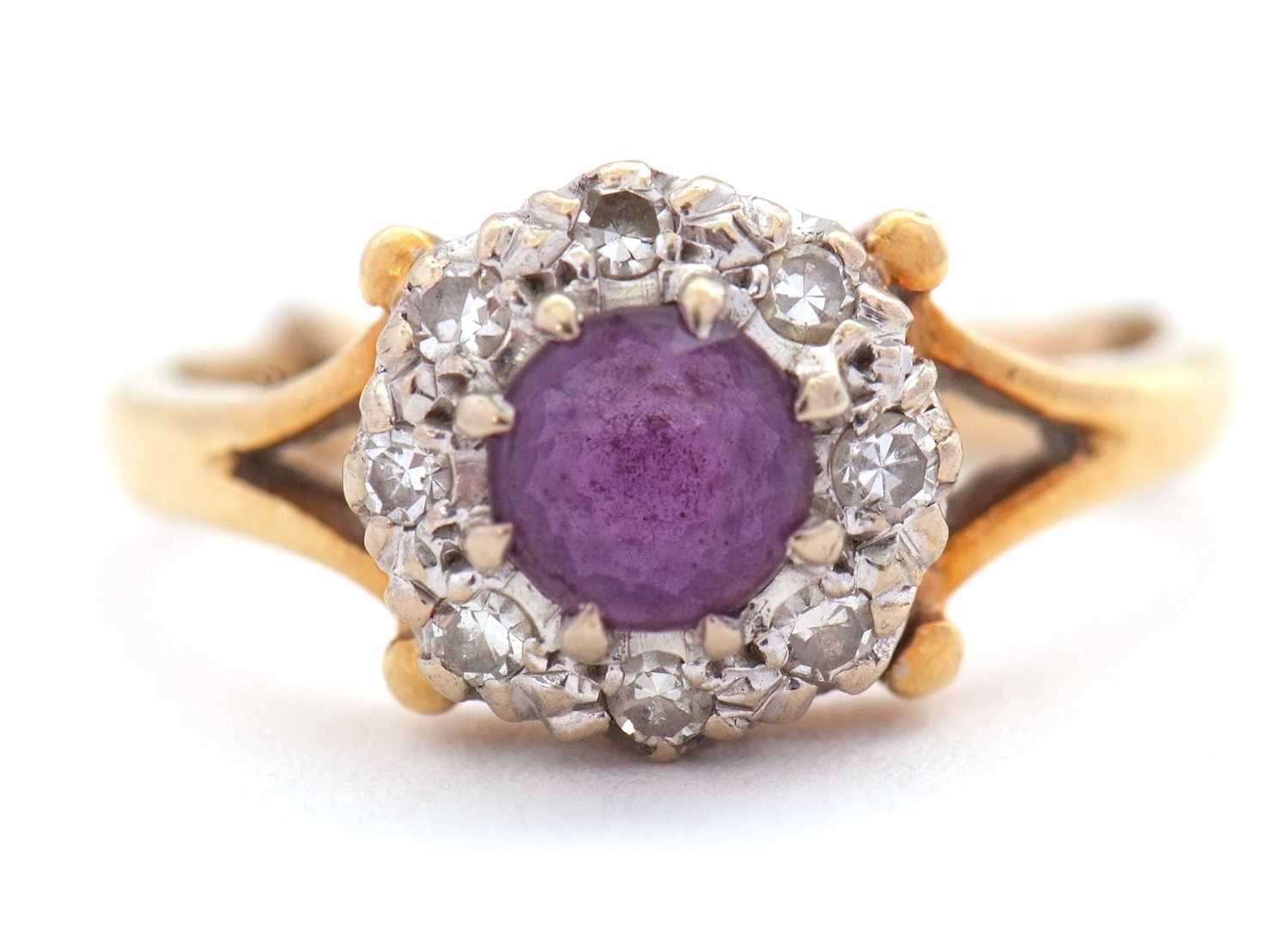 An 18ct amethyst and diamond ring, the central round amethyst surrounded by single cut diamonds,