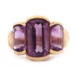 A 9ct amethyst ring, the three mixed cut amethysts, largest 14mm long, with tapered shoulders and