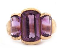 A 9ct amethyst ring, the three mixed cut amethysts, largest 14mm long, with tapered shoulders and