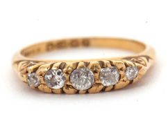 An 18ct diamond ring, set with five slightly graduated old mine cut diamonds, with tapered shoulders
