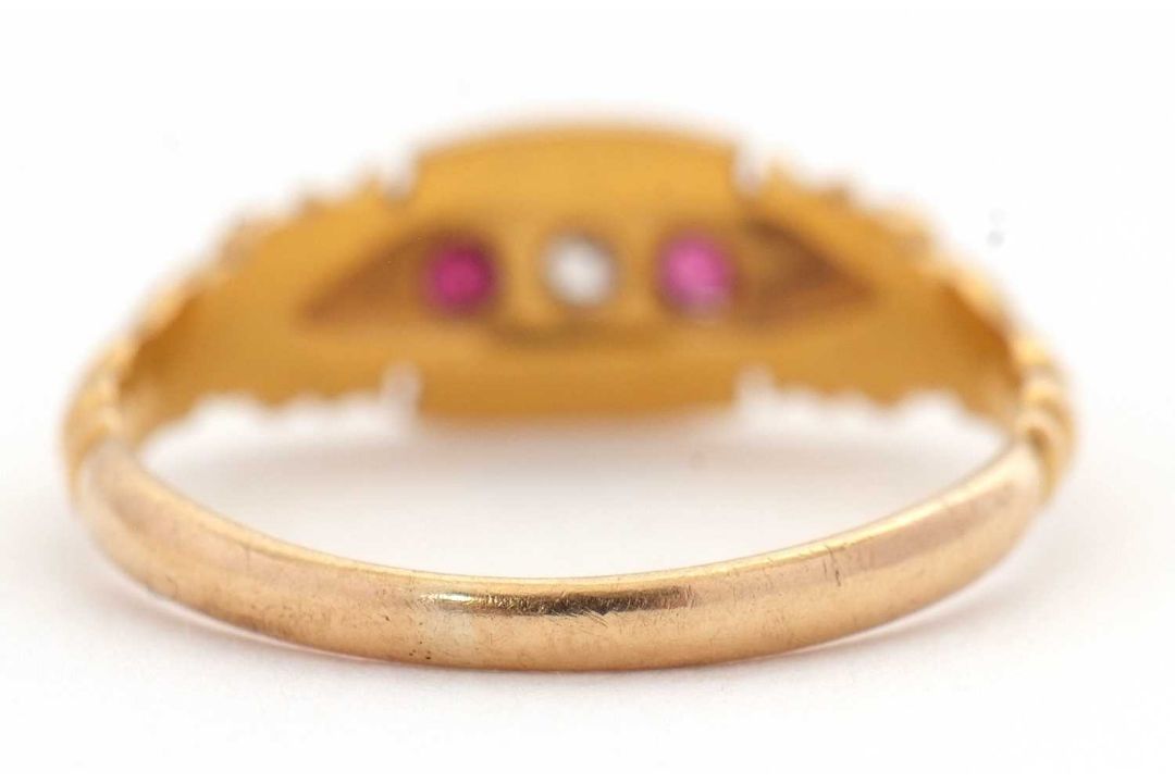 An Edwardian 18ct ruby and diamond ring, set with a central round diamond and a round ruby to either - Image 6 of 7