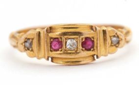 An Edwardian 18ct ruby and diamond ring, set with a central round diamond and a round ruby to either