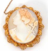 A cameo brooch, the oval shell cameo of a lady with vines in her hair, in unmarked yellow metal