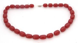 A 'cherry amber' bead necklace, with slightly flattened oval beads, approx.10 - 13mm diameter,