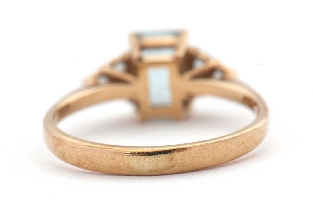 A 9ct aquamarine ring, set with an emerald cut aquamarine and three small round aquamarines to - Image 4 of 8