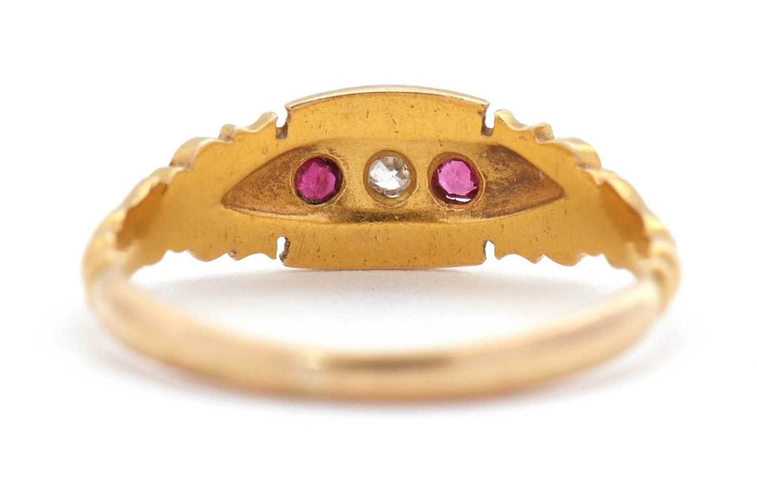 An Edwardian 18ct ruby and diamond ring, set with a central round diamond and a round ruby to either - Image 4 of 7