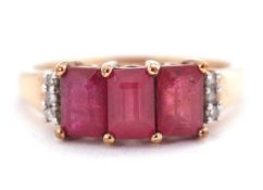 A 9ct ruby and diamond ring, the three emerald cut rubies with three small single cut diamonds to