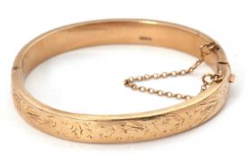 A 9ct bangle, the hinged bangle with engraved decoration throughout, stamped 375 and hallmarked