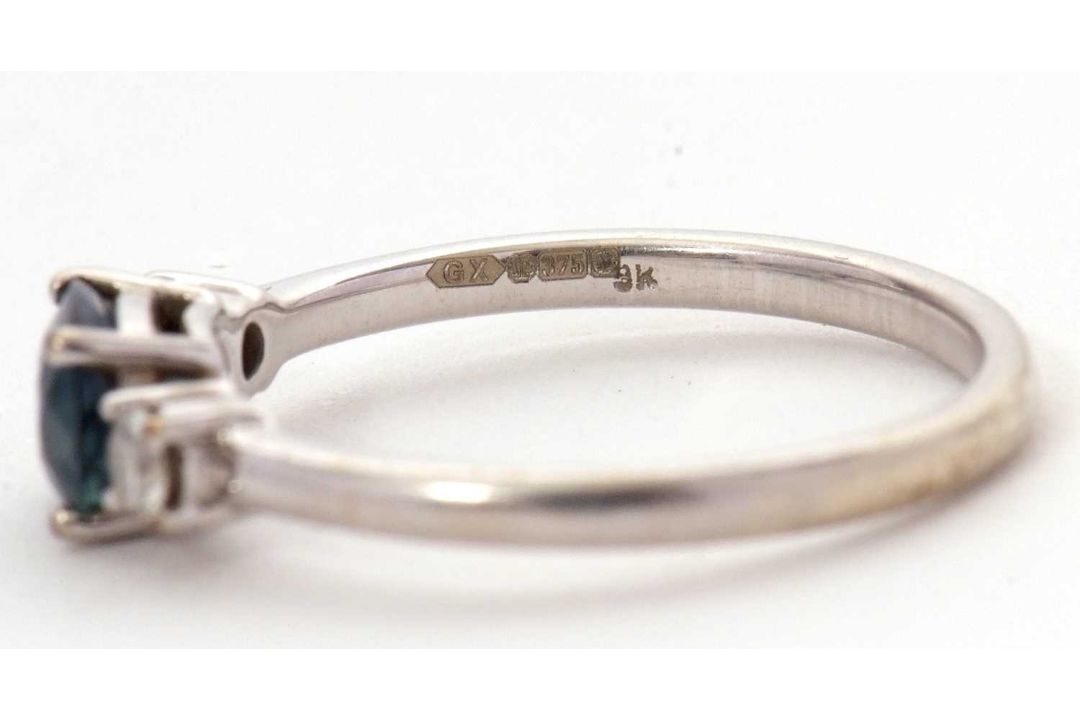 A 9ct sapphire and diamond ring, the oval blue-green sapphire set to either side with a round - Image 8 of 8