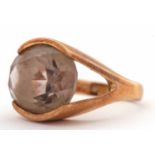 A 9ct smokey quartz ring, the oval smokey quartz in a horizontal tension settting, with split