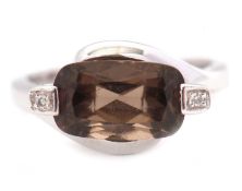 A 9ct smokey quartz and diamond ring, the mixed cut smokey quartz with a single cut diamond to