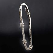 A WHITE METAL DIAMOND SET BRACELET.