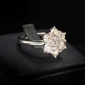 AN 18CT GOLD SEVEN STONE DIAMOND CLUSTER RING.