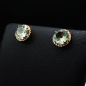 A PAIR OF 18CT GOLD GREEN GEMSTONE AND DIAMOND STUD EARRINGS.