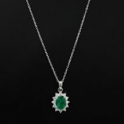 AN 18CT WHITE GOLD EMERALD AND DIAMOND PENDANT NECKLACE.