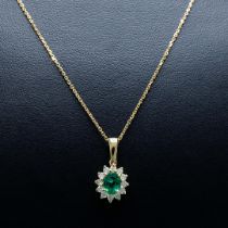 A 9CT GOLD EMERALD AND DIAMOND CLUSTER NECKLACE.