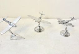 SET OF THREE AEROPLANE DESK ORNAMENTS IN POLISHED METAL.