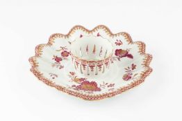 A Continental porcelain cup stand, of lobed dished form with central pierced cup holder, painted