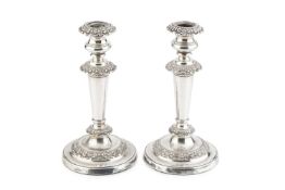 A pair of George IV silver candlesticks, the tapering stems with foliate cast decoration, on