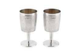 A pair of silver goblets, of textured, slightly tapered form, on plain tapering stems and circular