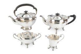 An Edwardian silver four piece tea service, of shaped oval form, on paw feet, comprising teapot, tea