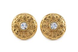 A pair of ear clips by Chanel, each circular panel centred with a white paste bordered by