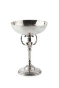 A George V silver goblet, the wide planished bowl on three c-scroll supports and tapering stem, on