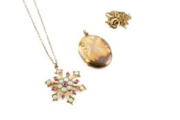 A gem set pendant on chain, modelled as a snowflake of cabochon opals spaced by red stones,