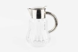 An early 20th century glass lemonade jug with silver plated mounts, having slice cut shaped body,