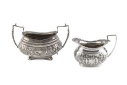 A George III silver twin handled sucrier, embossed with flowering foliage and having beaded