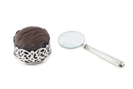 An Edwardian silver mounted pin cushion, of circular form, pierce-decorated with scrolling