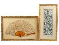 A 19th Century lace fan worked with flowering foliage and simulated amber sticks, framed and glazed;