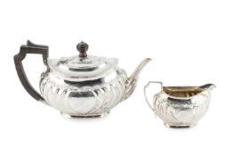 A late Victorian silver teapot and matching milk jug, of shaped and fluted oval form, having borders