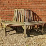 A teak half-round tree bench
