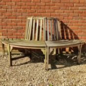 A teak half-round tree bench