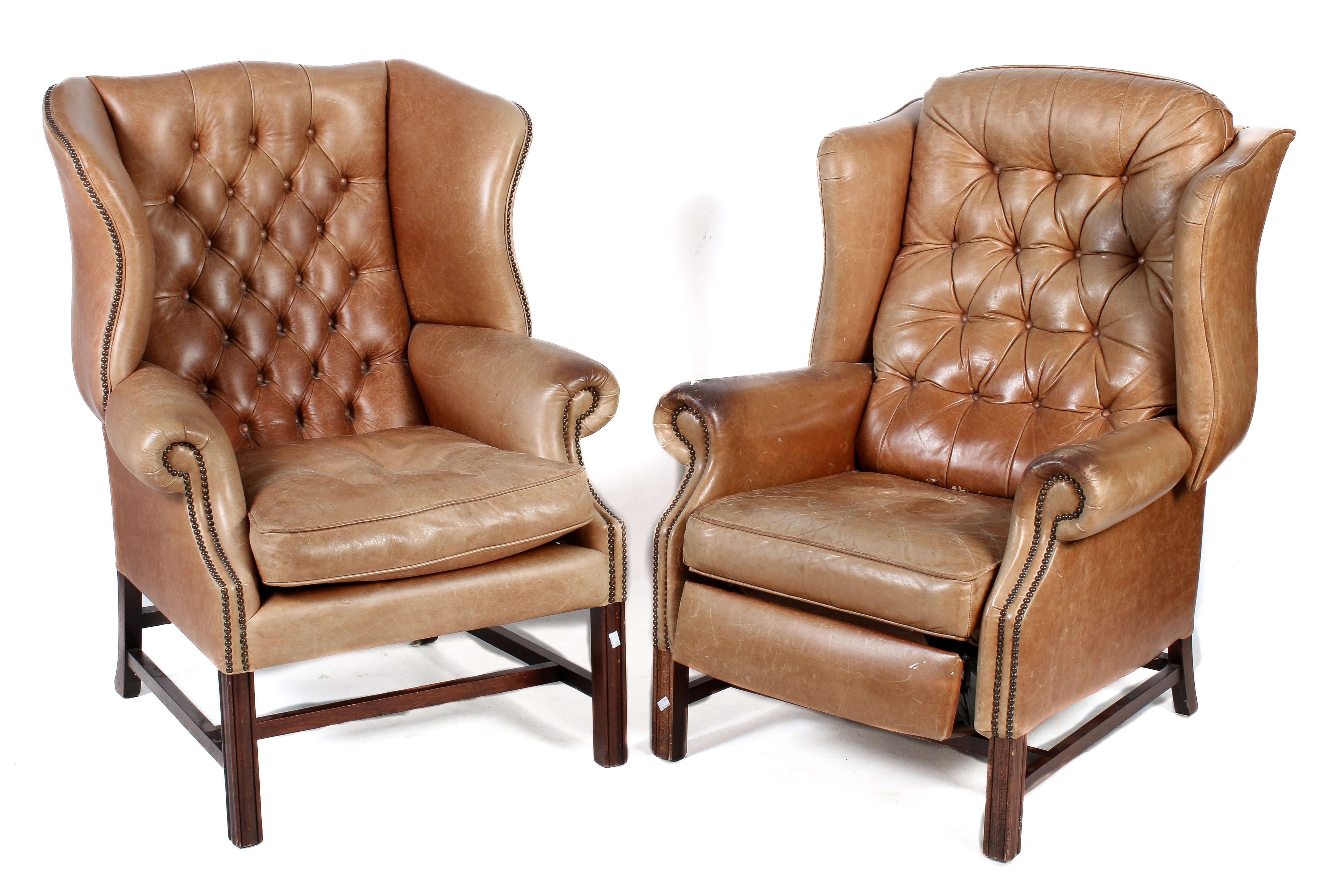 Two tan leather wing back armchairs.