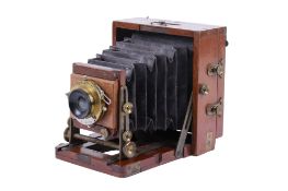 An antique brass and mahogany quarter-plate camera.